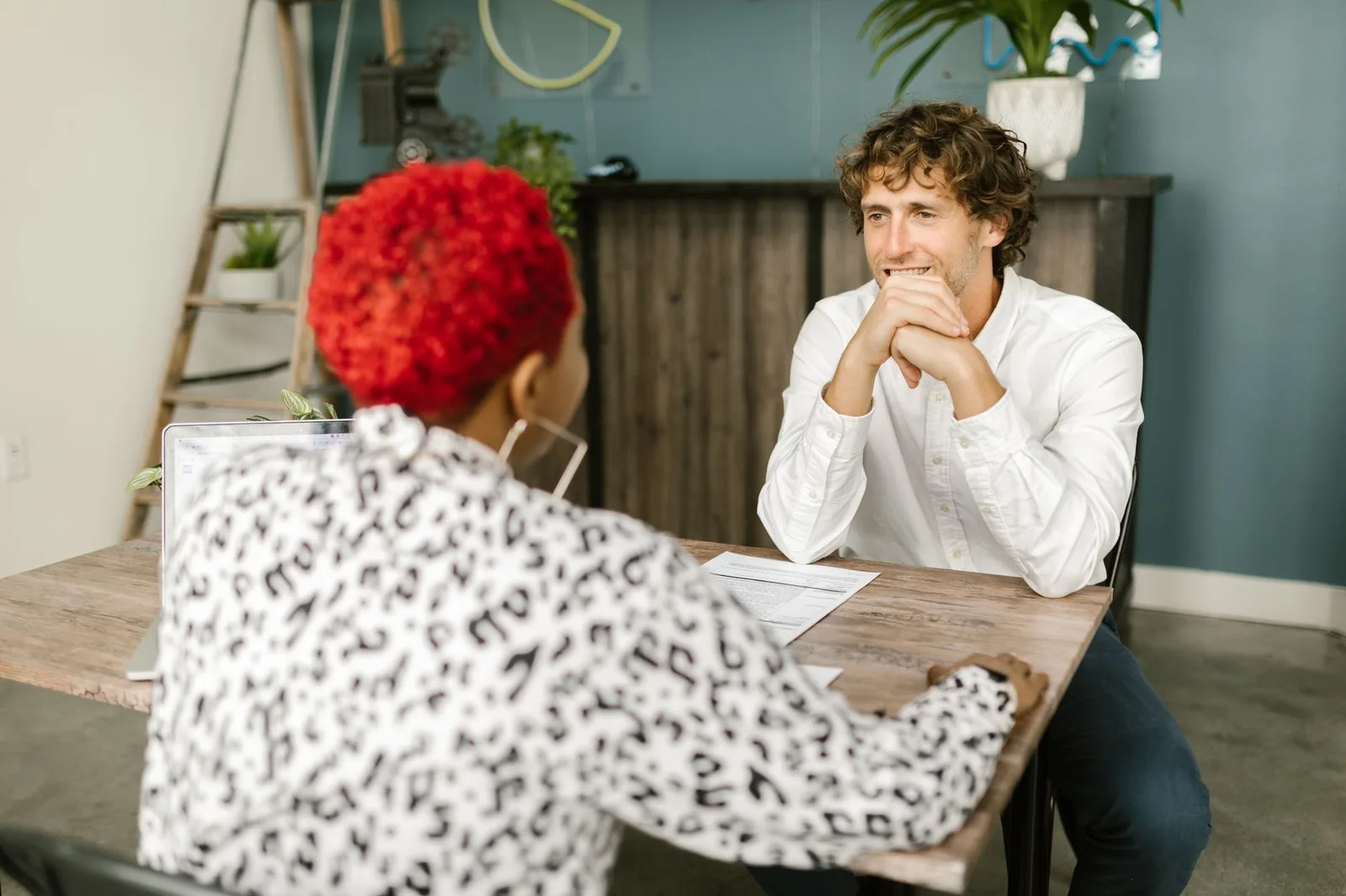 Two people talking across a desk with a single document between them