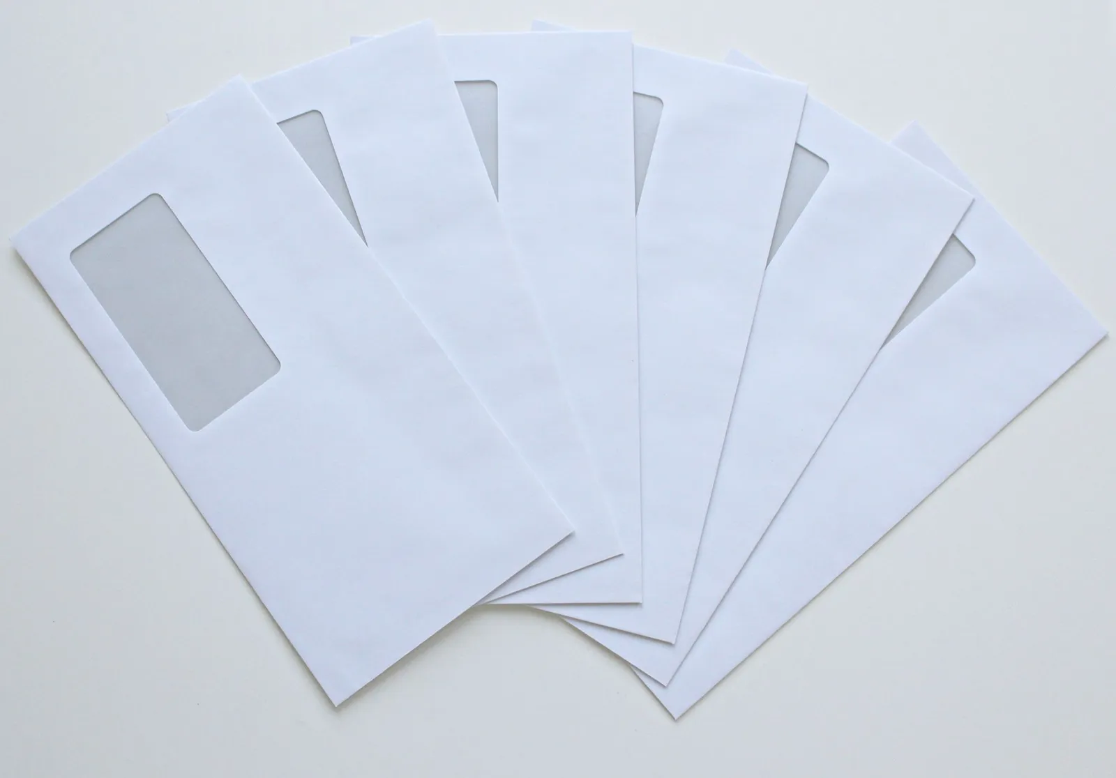 A set of white window envelopes fanned out on a flat surface