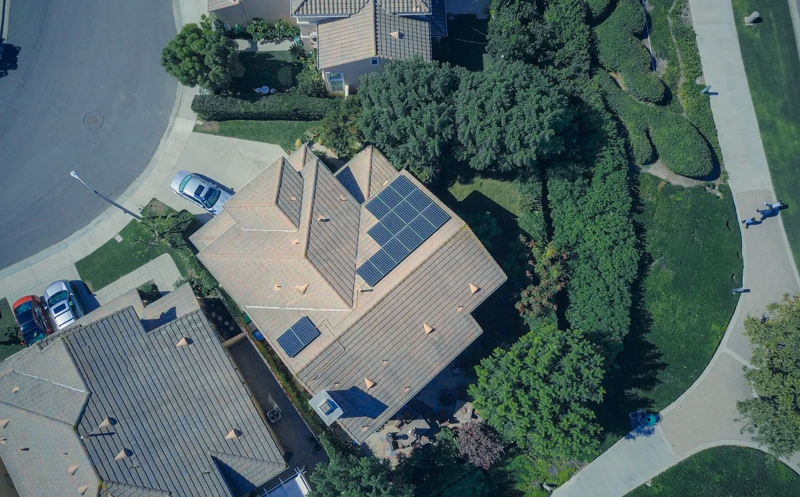 Aerial view of suburban homes with solar panels on a tile roof