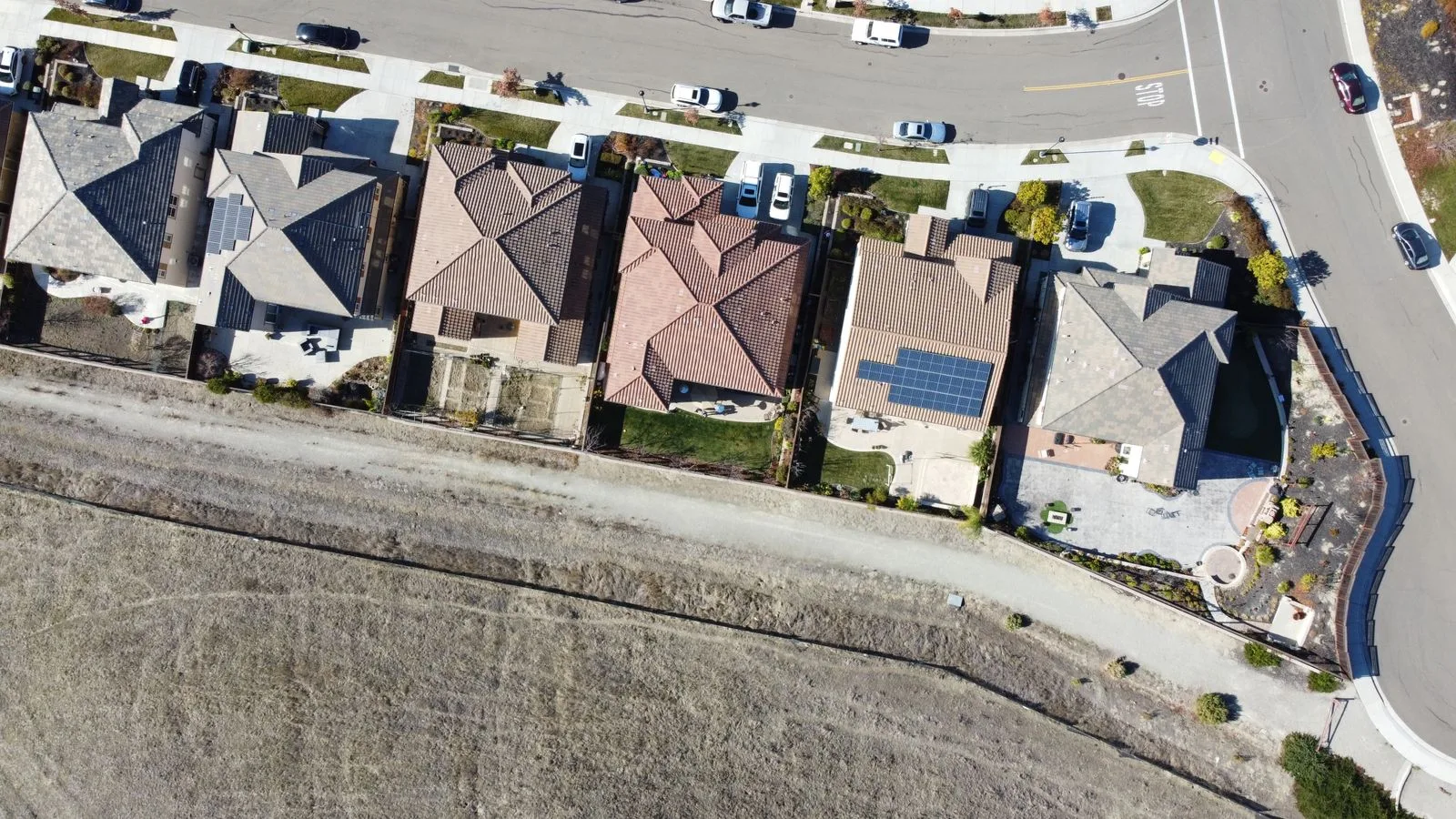Aerial view of a California suburban street with rooftop solar arrays on two of the houses