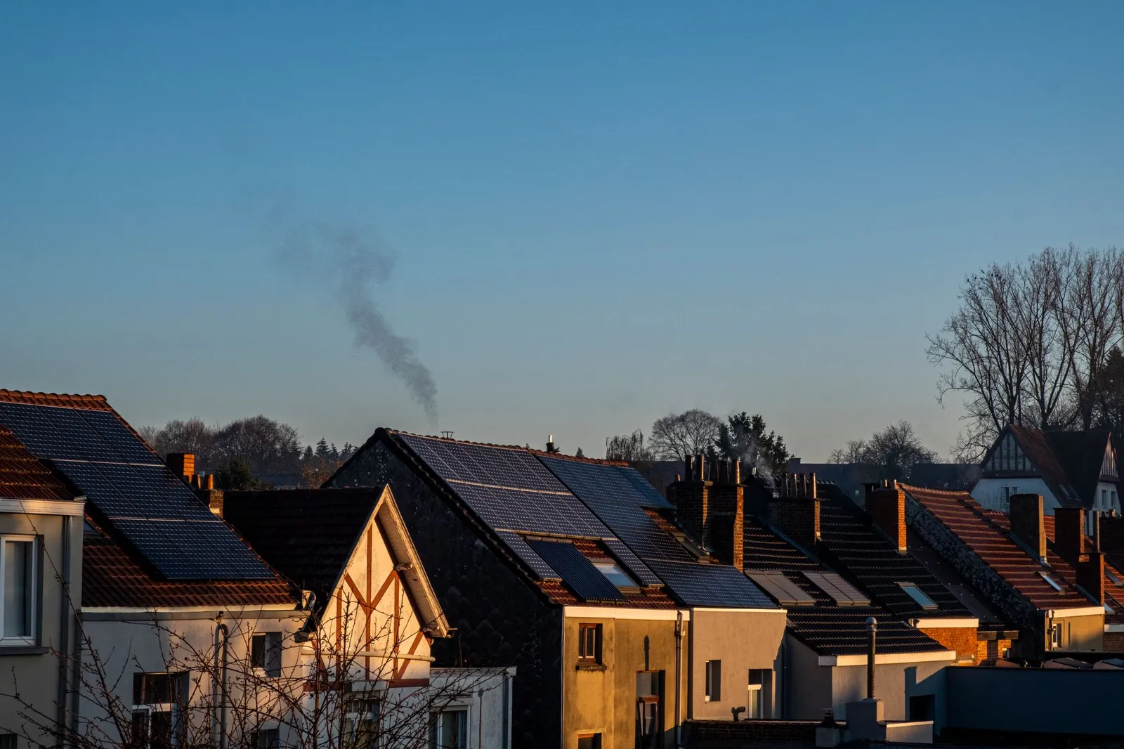 A row of suburban houses with solar panels on their rooftops