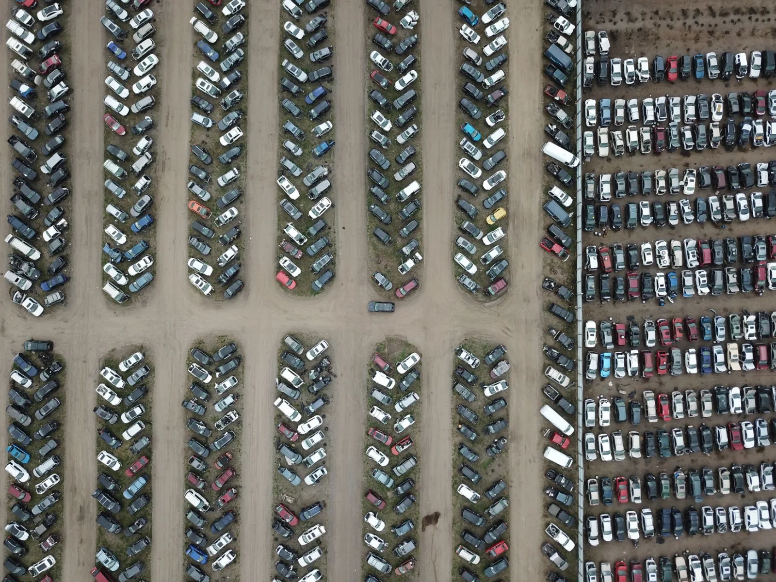Aerial view of rows of totaled vehicles parked at a salvage auction lot