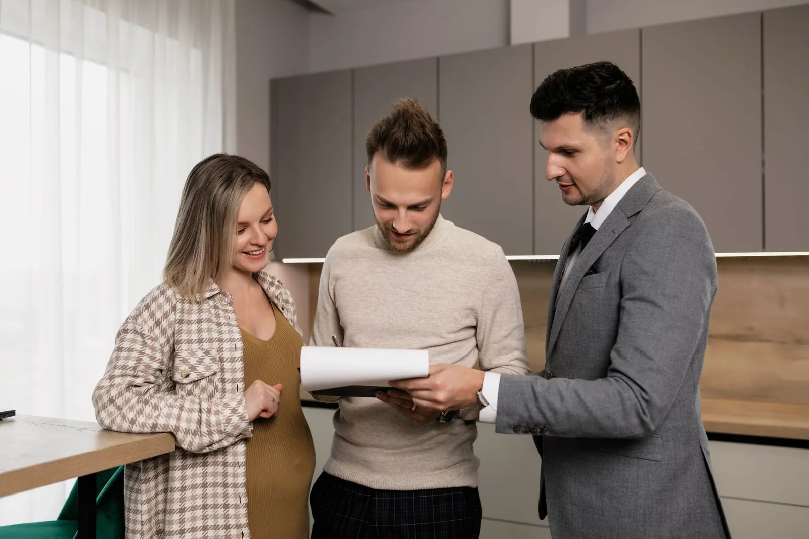A salesperson presenting a printed contract to a seated couple indoors